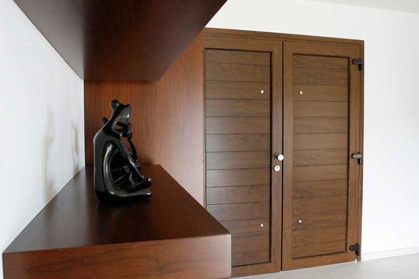 Dark timber double interior doors beside a wooden staircase