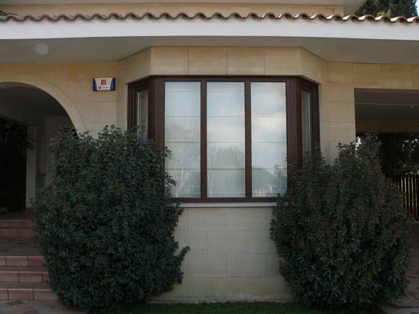 Woodgrain bay window on a stone-faced house front