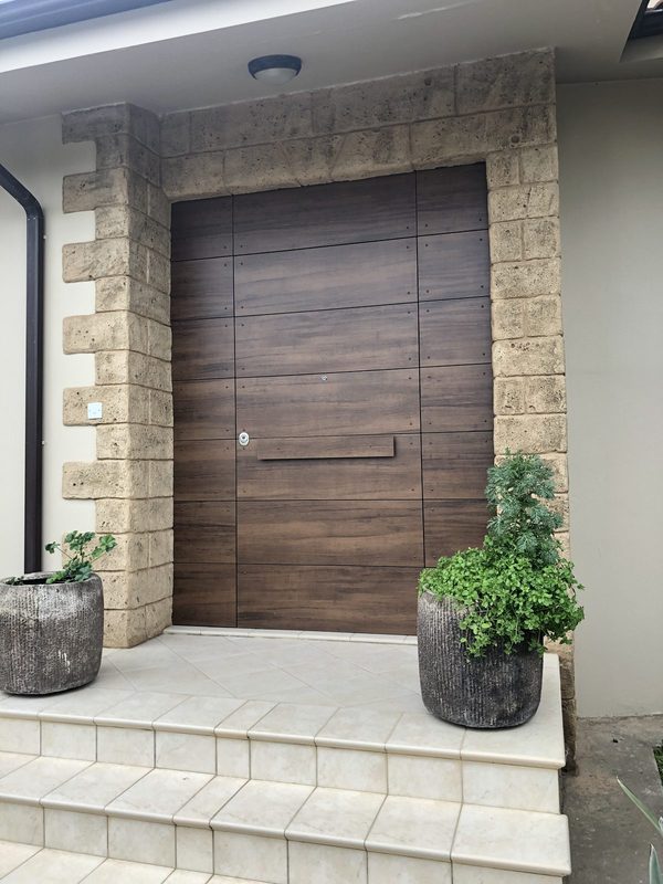 Oversized timber entrance gate in stone facade